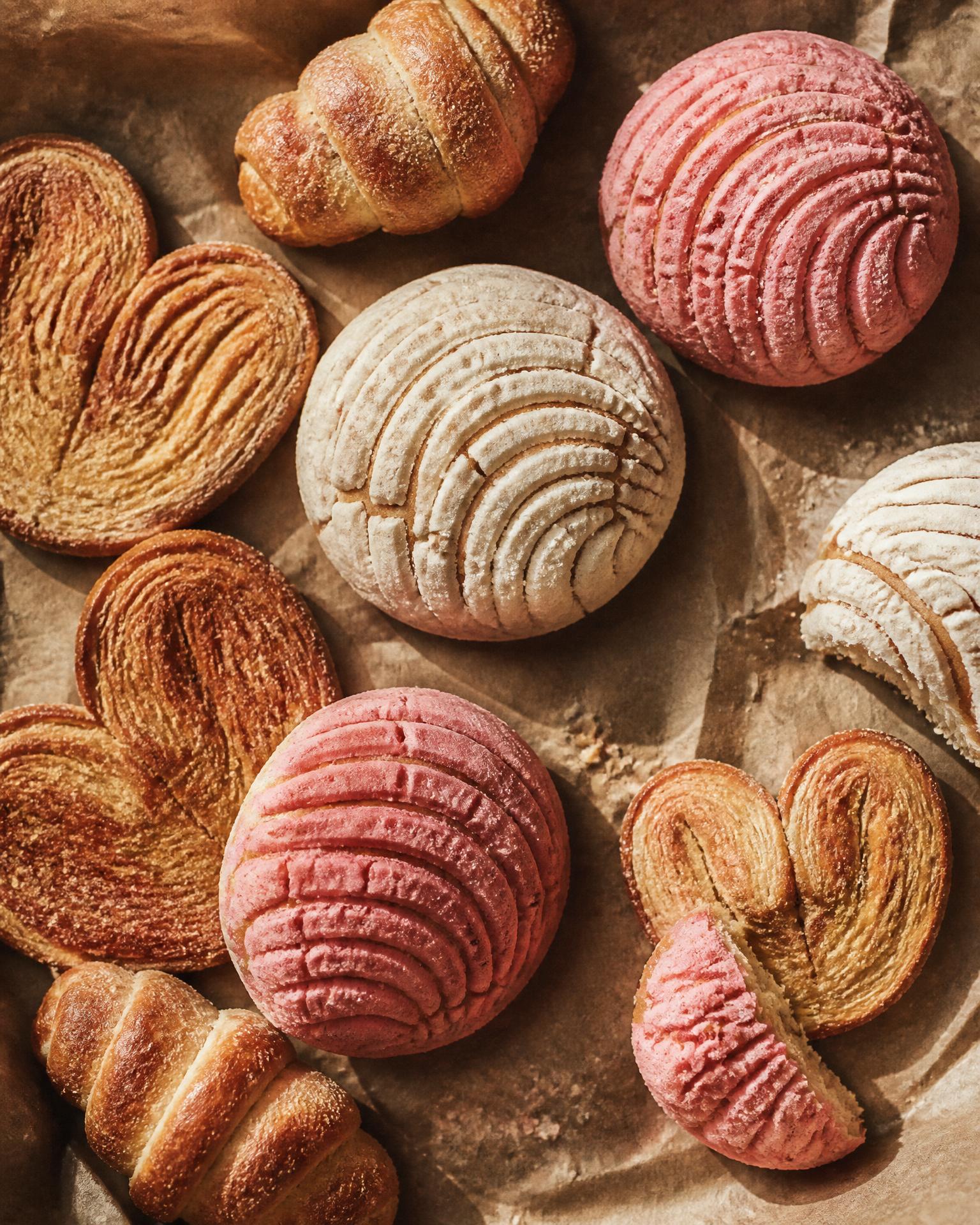Assortment of conchas and pan dulce on parchment
